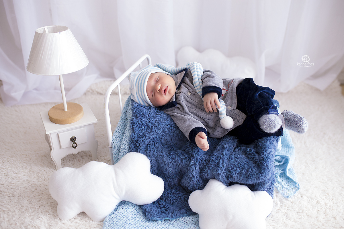 o bebe esta deitado no cenario para suas fotos mensais