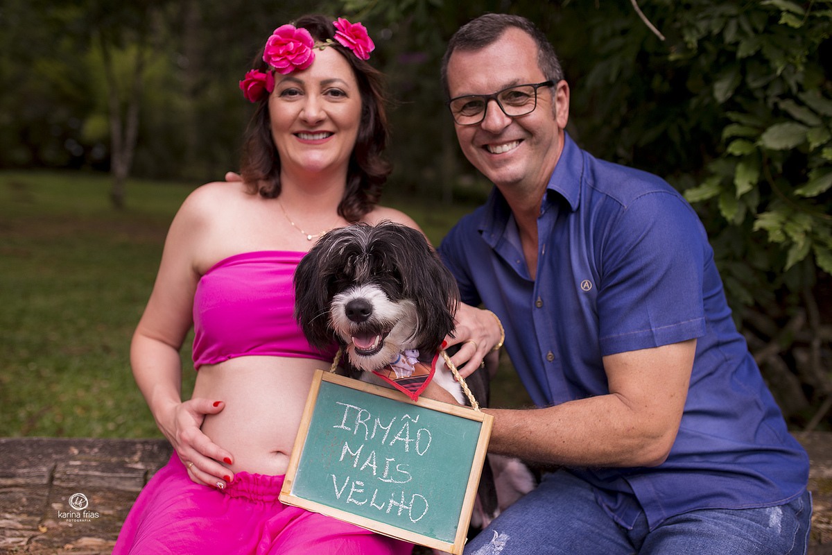 no ensaio de gestante o cachorro segura a plaquinha