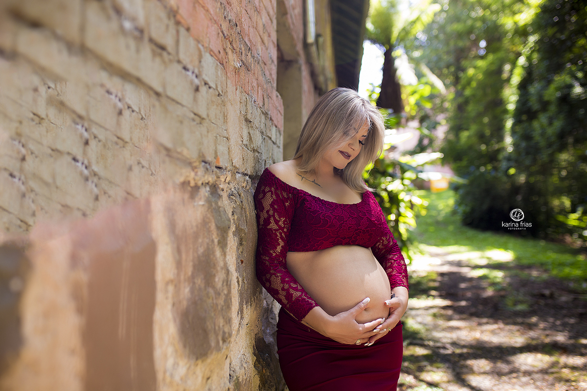 no ensaio externo de gestante, a mae olha para a barriga