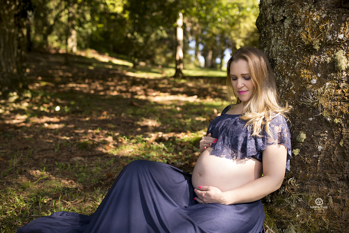 a gestante olha para a barriga no seu ensaio externo