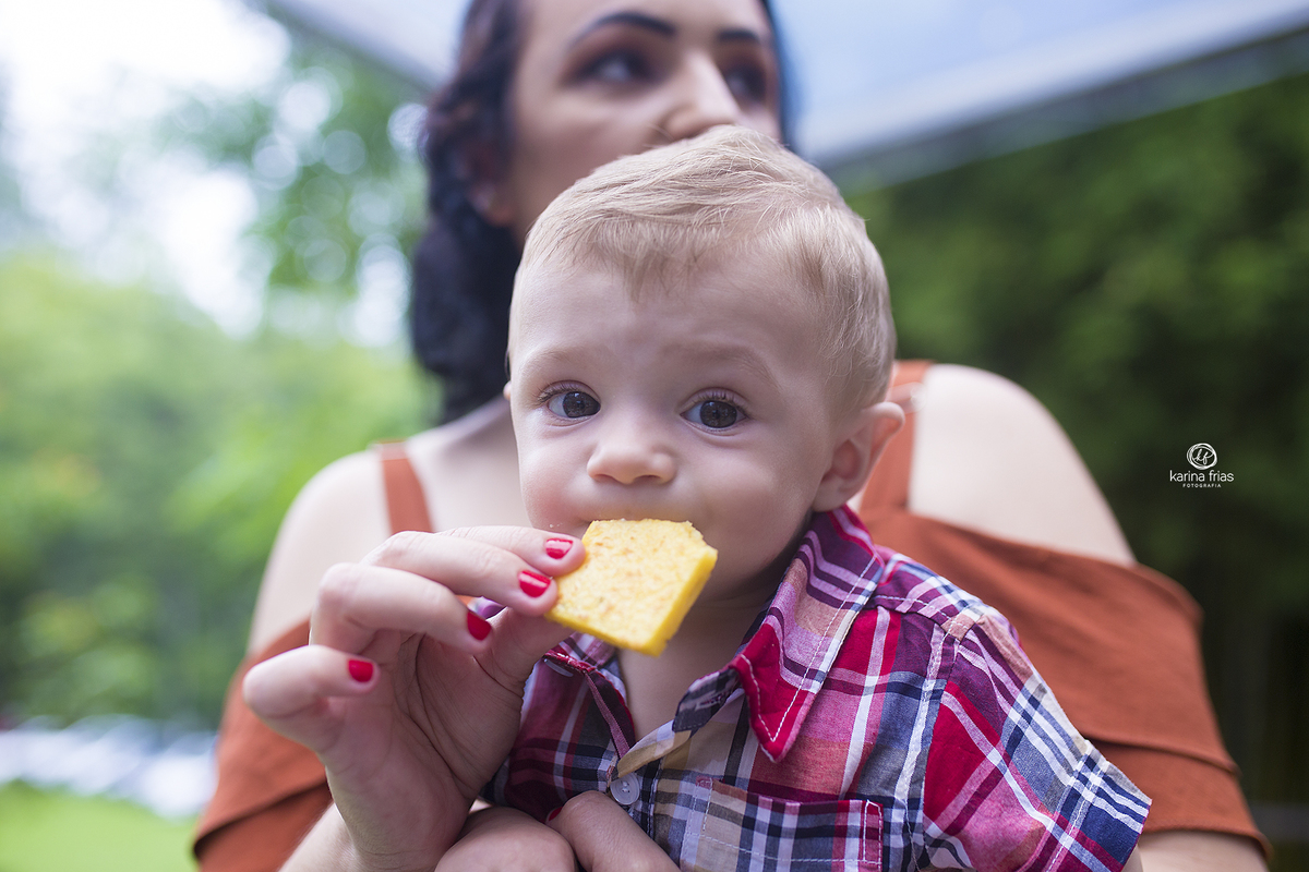 o menino come durante a sessão de fotos no aniversario