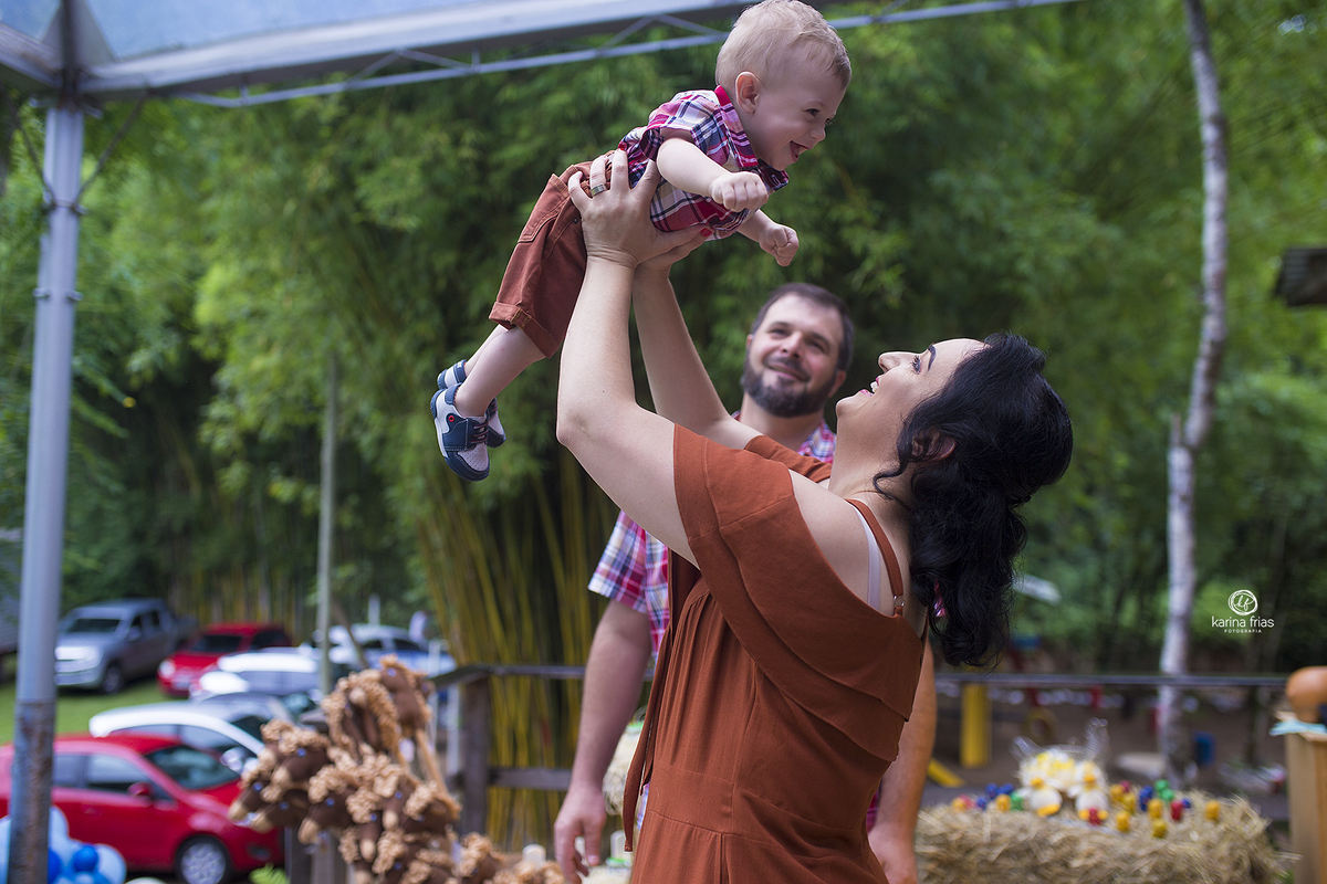 a mae joga o filho para cima durante ensaio de aniversario
