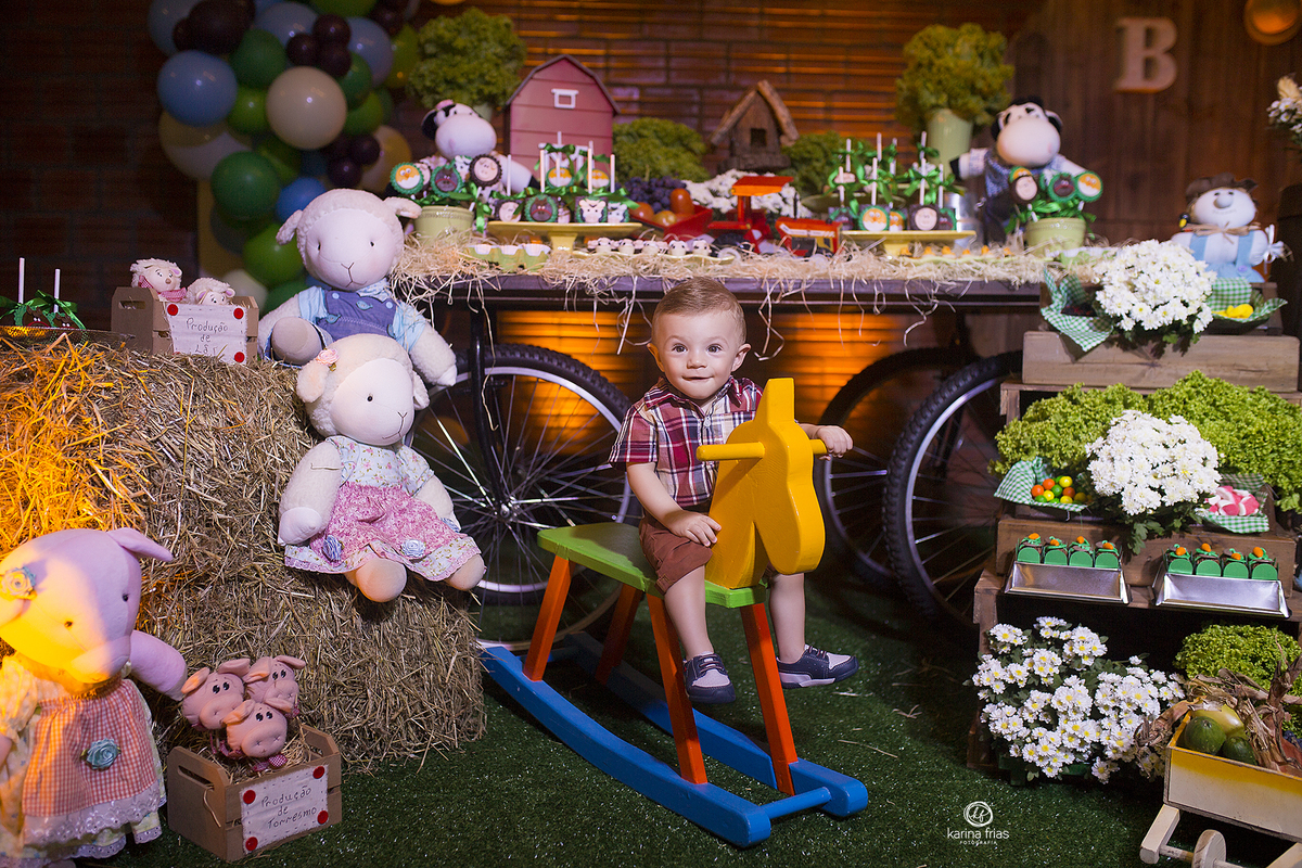 o menino esta frente a mesa de doces no aniver infantil