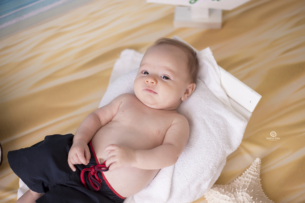 no ensaio infantil, o bebe olha para a fotografa de crianças de caxias do sul-rs