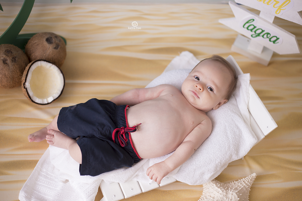 o menino esta deitado para suas fotos de dois meses