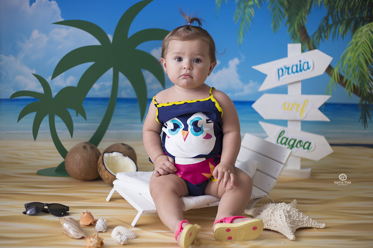 a menina esta sentada na cadeira de praia para as fotos mensais