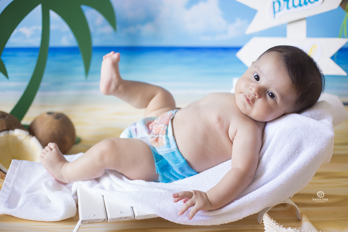 o bebe esta deitado para suas fotos mensais