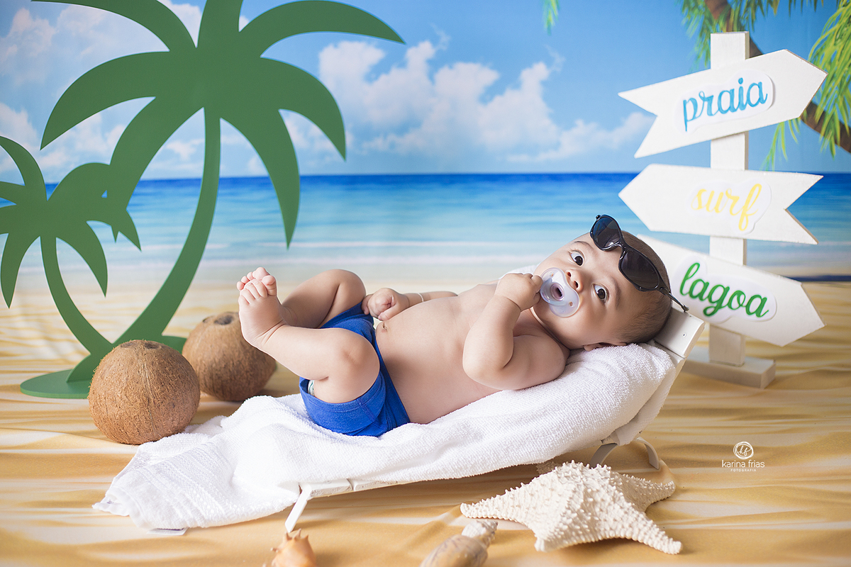 o bebe esta deitado no cenario de praia