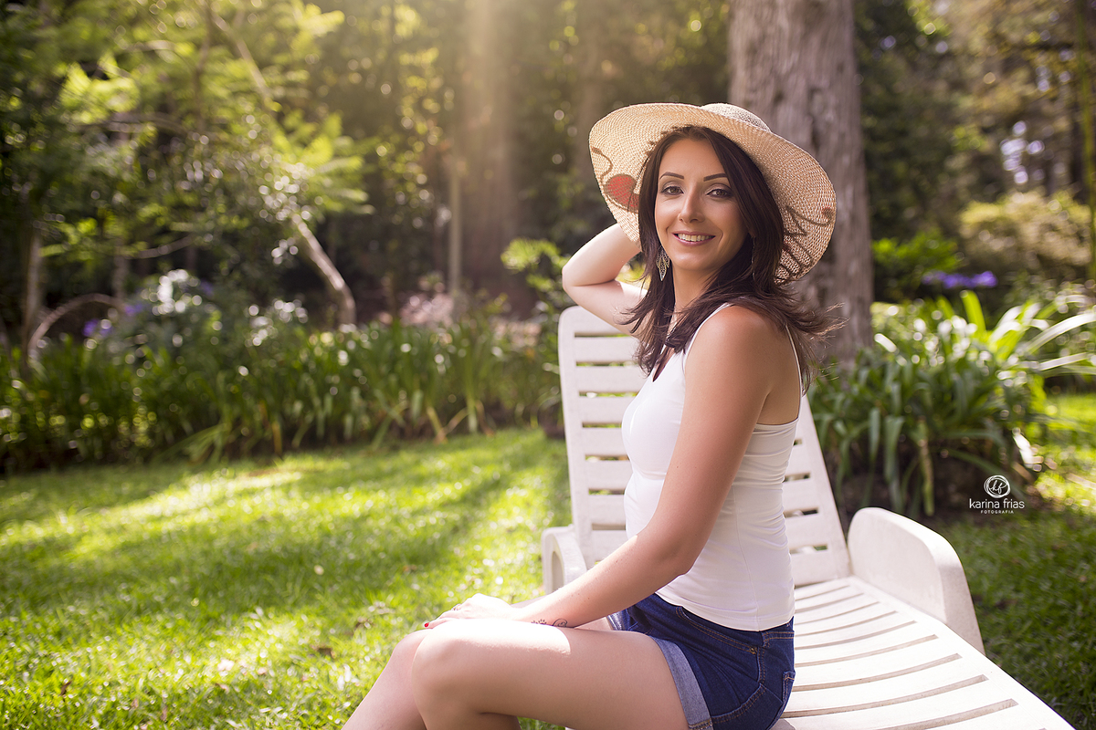 a menina segura o chapeu na sessão de fotos