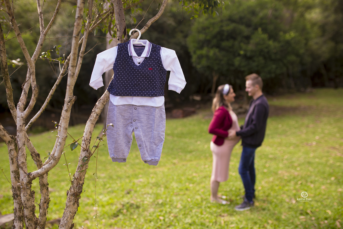 os pais estao ao fundo e na frente tem a roupinha do bebe