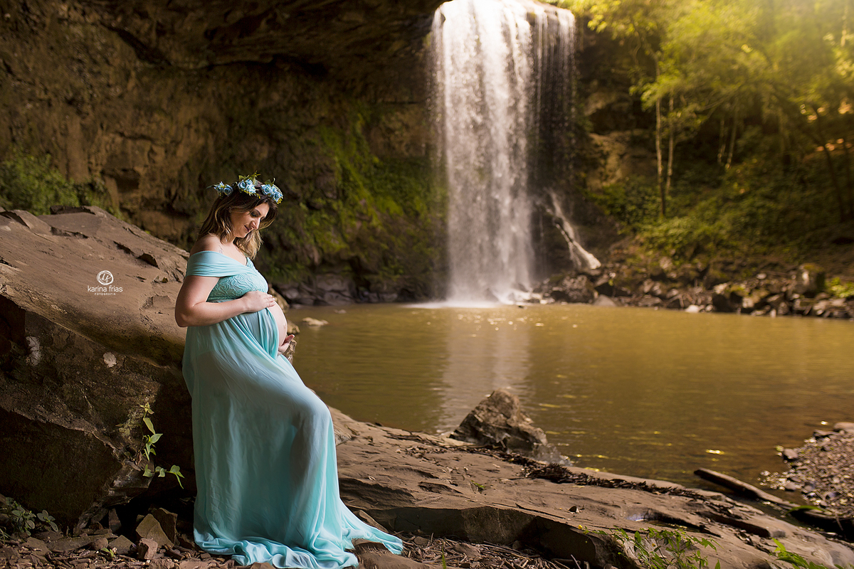 a gestante olha a barriga durante fotos para o book