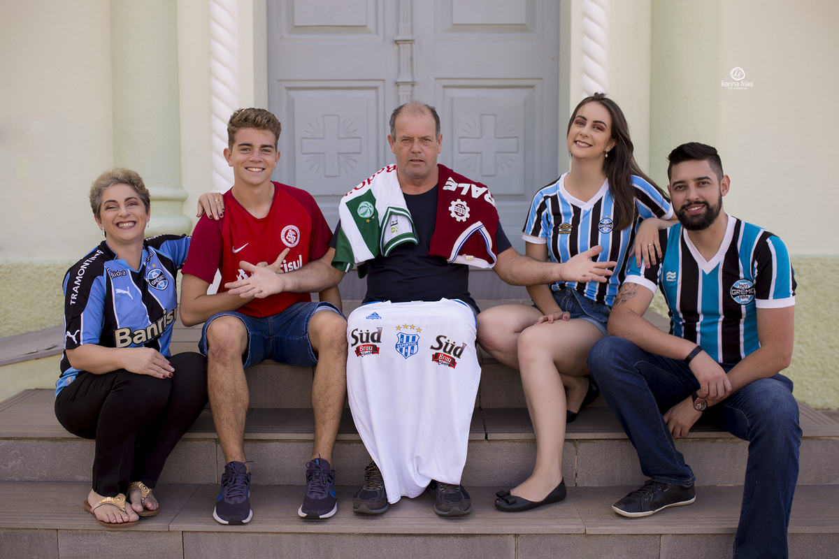 a familia posa com camisetas de times