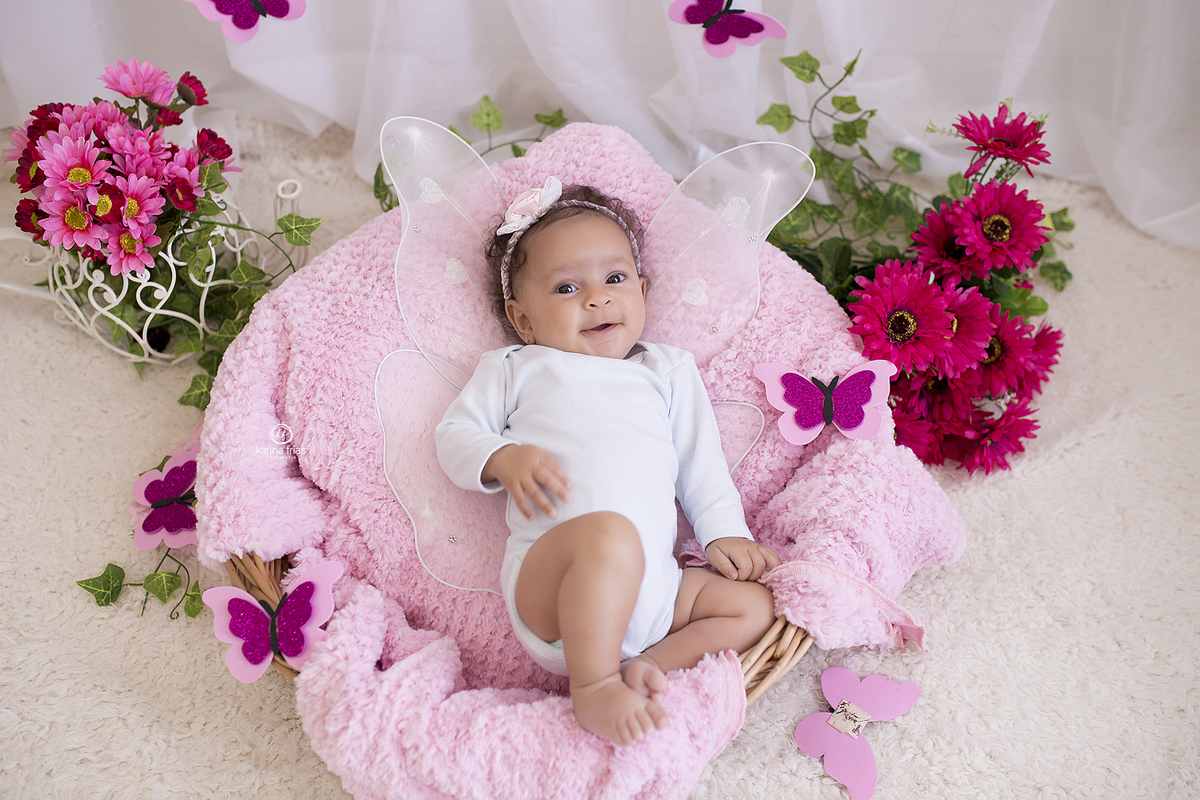 a bebe esta deitada no cenario de borboleta