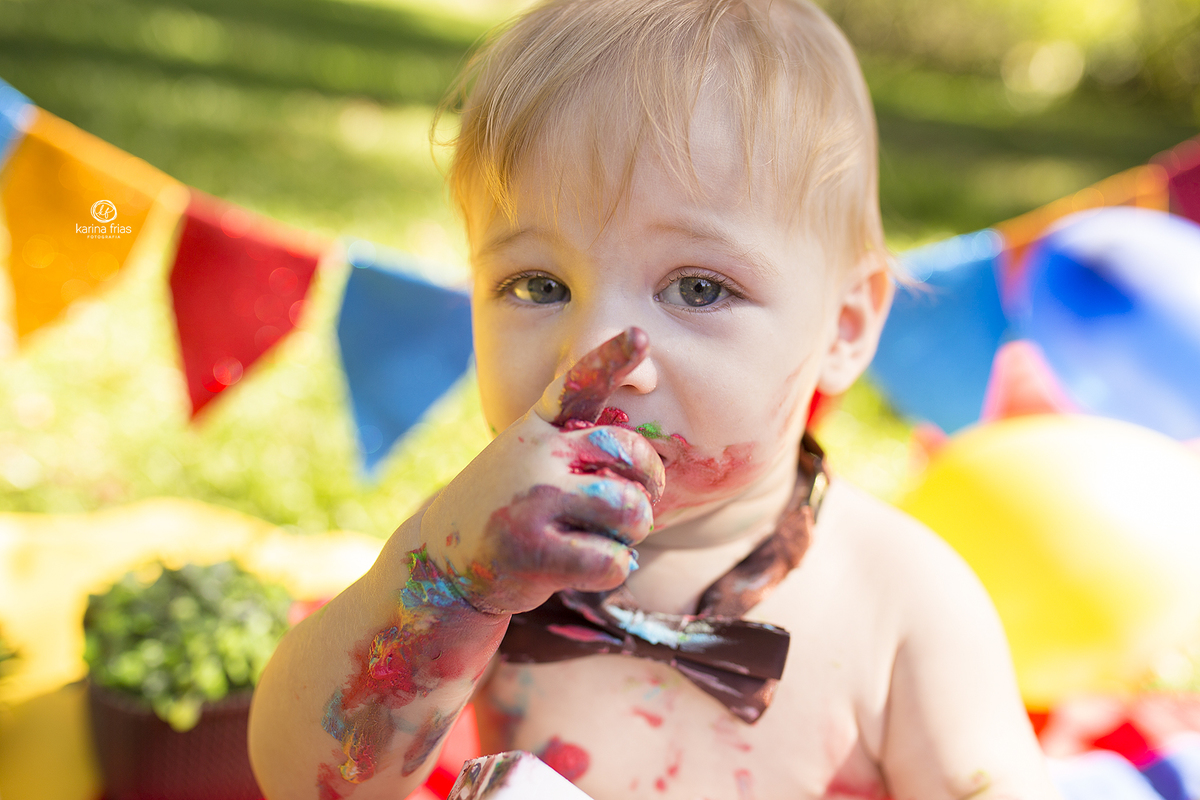 o menino esta todo sujo durante o ensaio com o bolo
