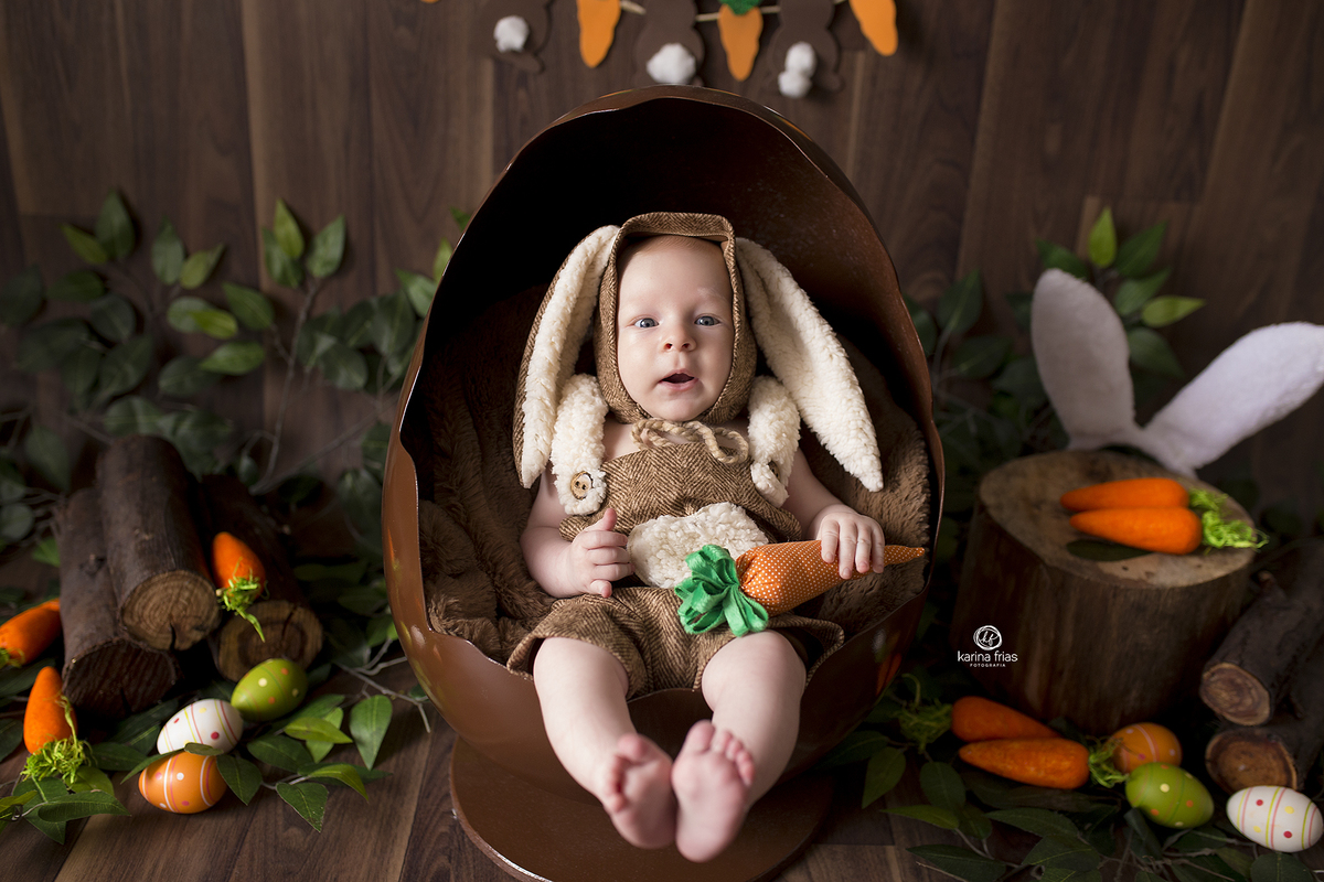 o menino esta sentado dentro do ovo de pascoa