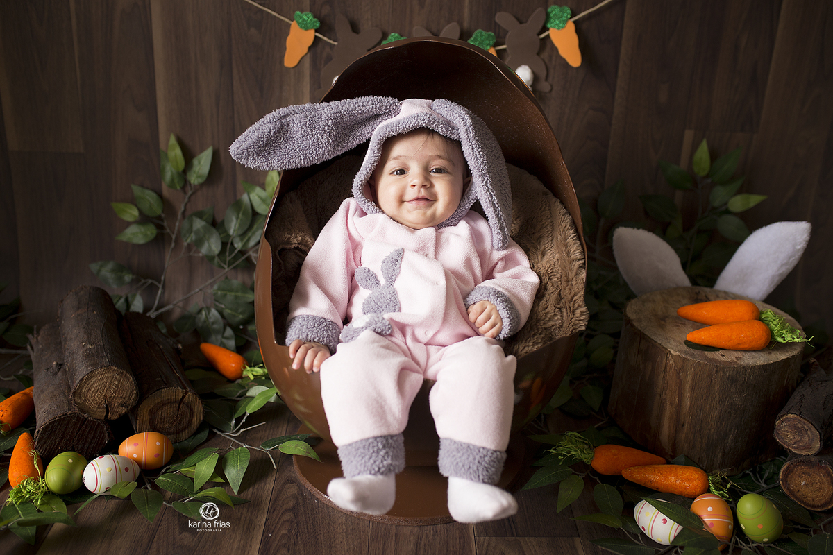 a menina esta sentada dentro do ovo de pascoa para as fotos infantis