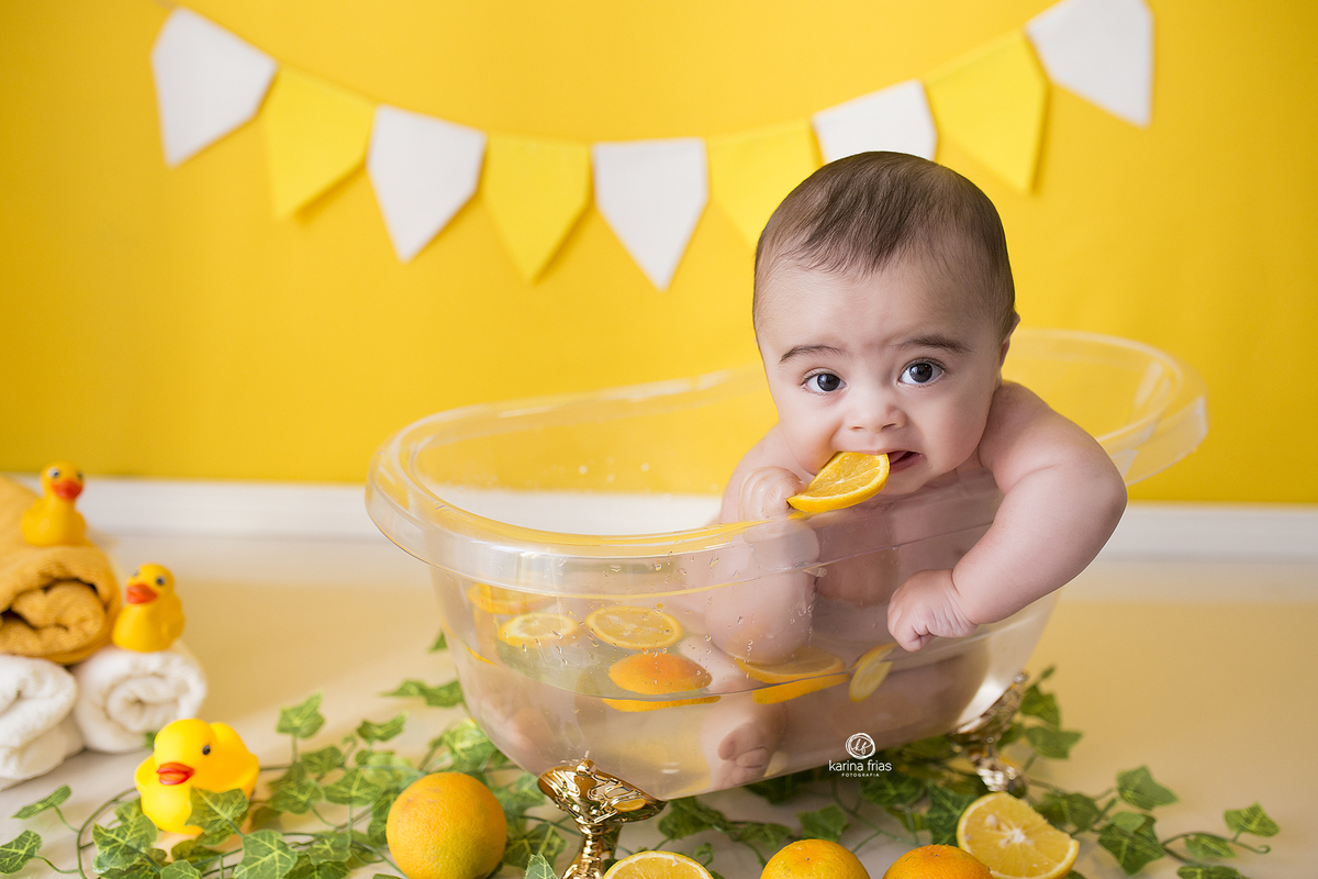 o menino esta com a laranja na mao para as fotos mensais