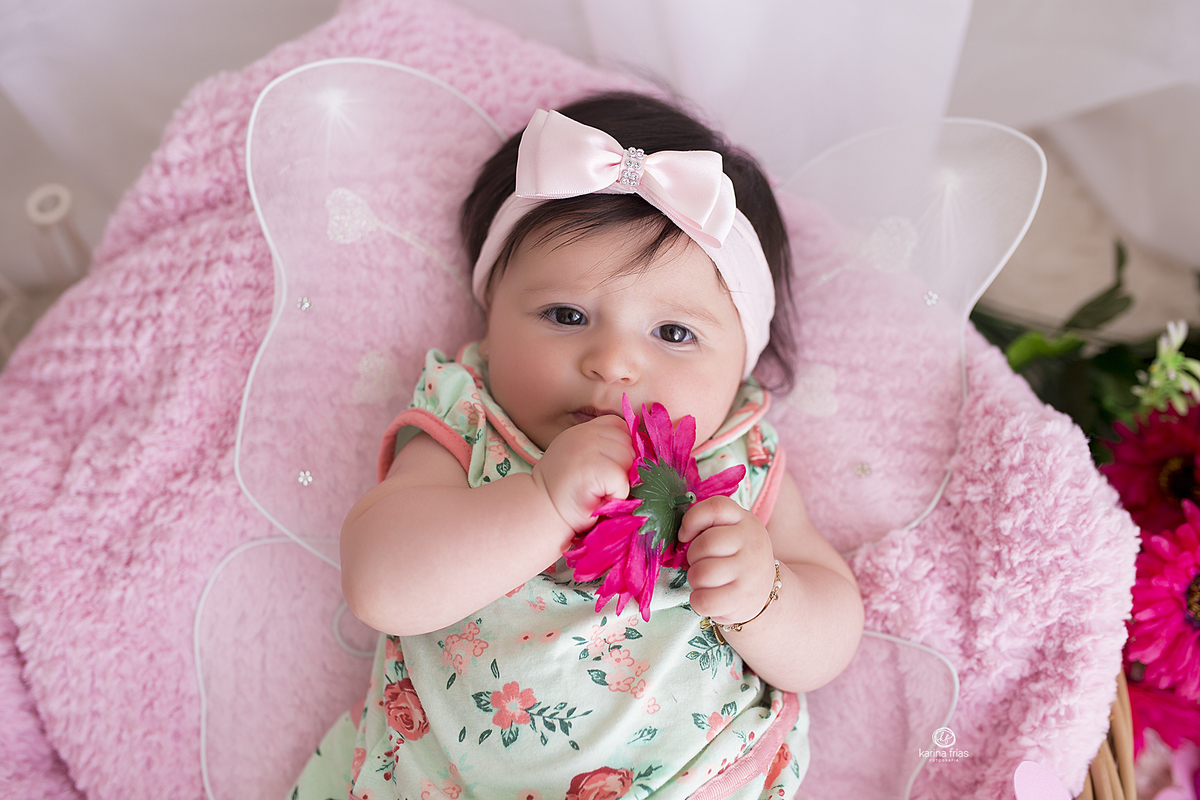 a menina segura a flor durante a sessão de fotos