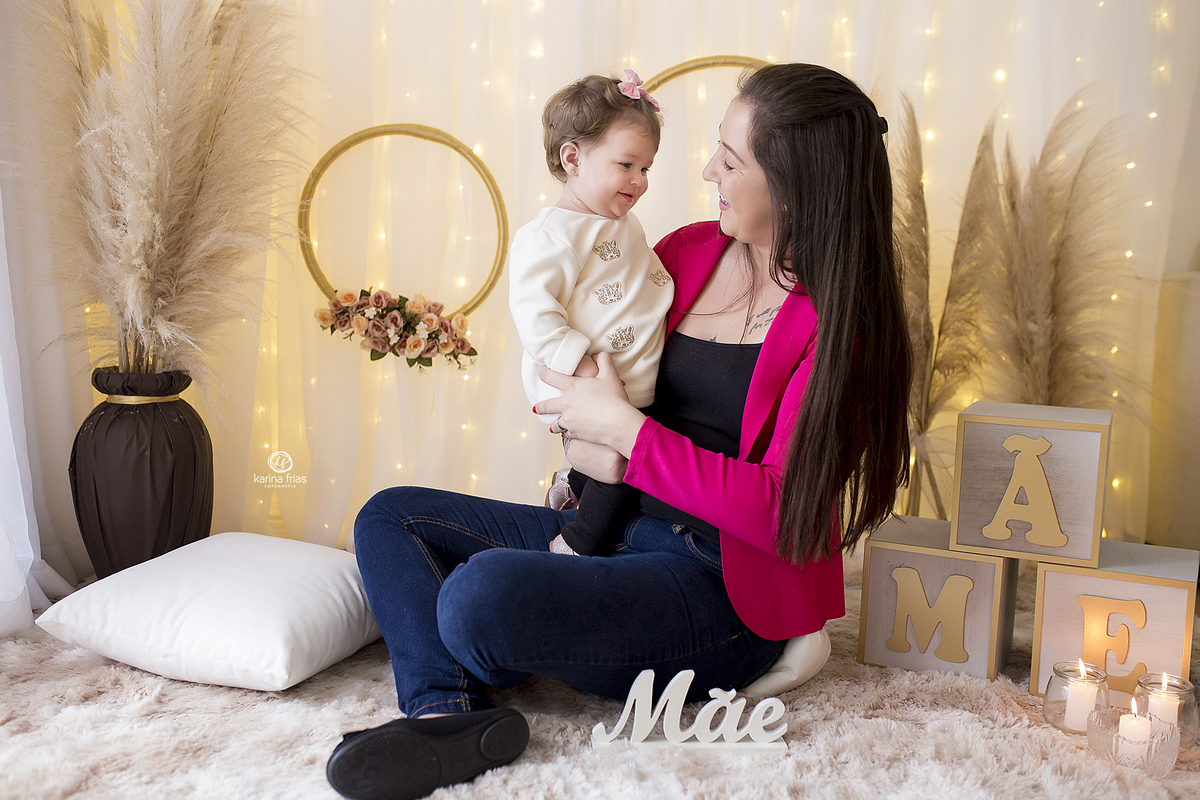 a mae segura a filha no colo durante sessão de dia das mães