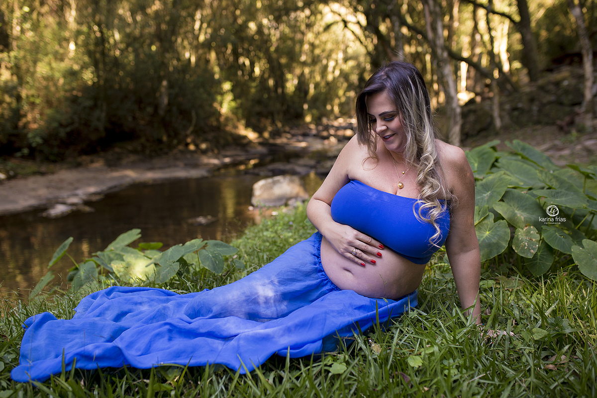 a gestante olha para a barriga no ensaio externo