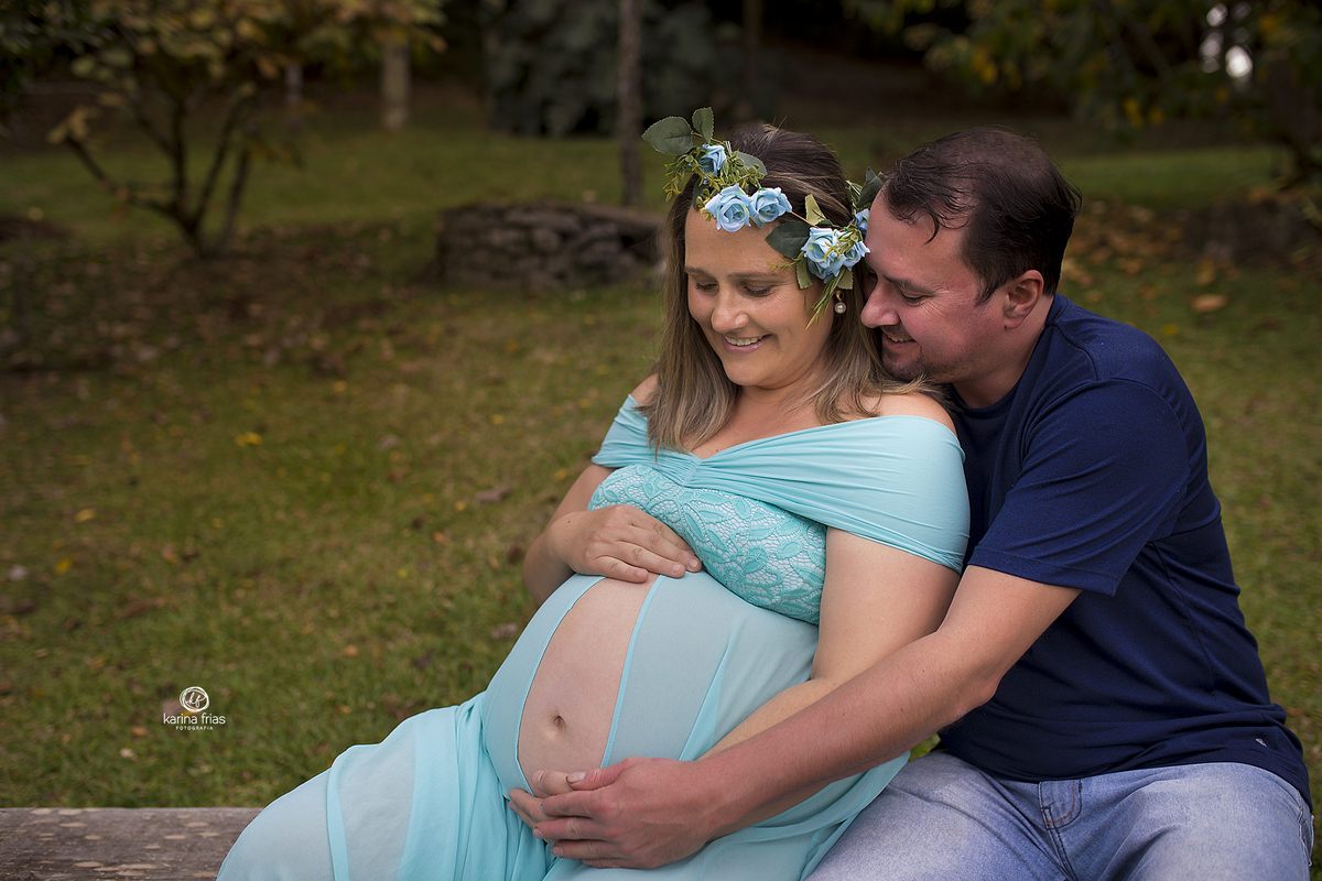 no ensaio de gestante os pais olham para a barriga