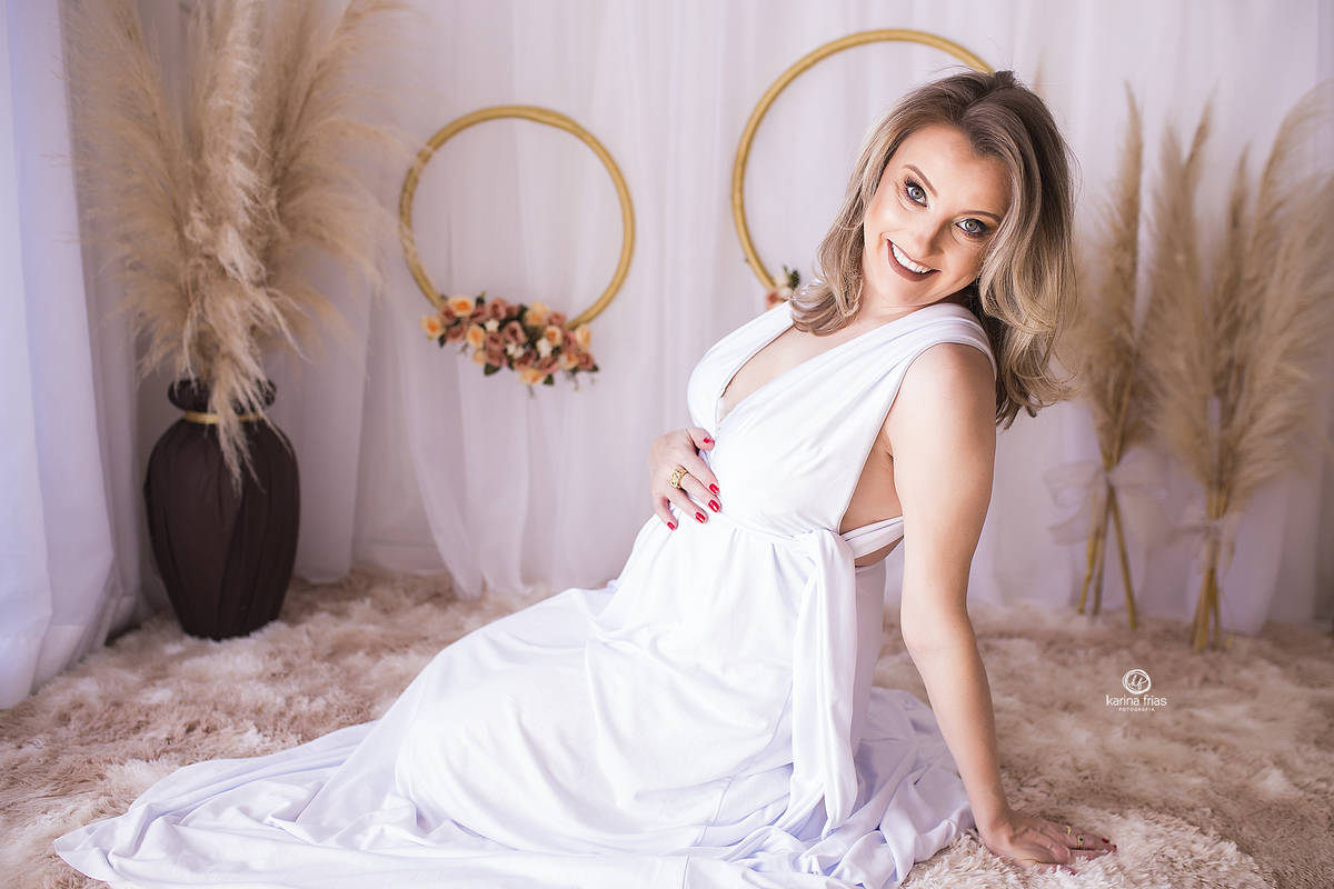 a mae senta no chao durante ensaio de gestante