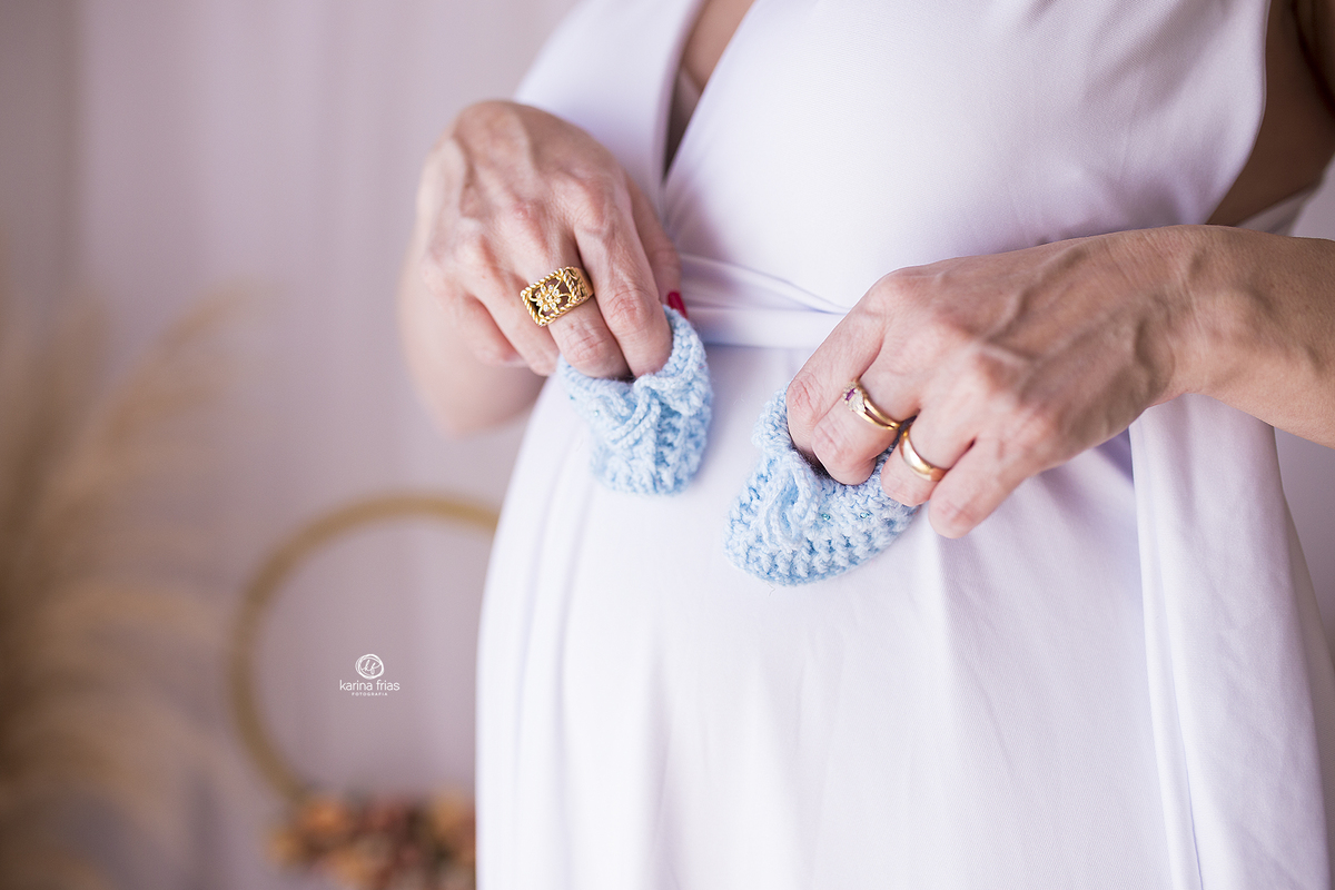 a mae apoia os sapatinhos do bebe no ensaio