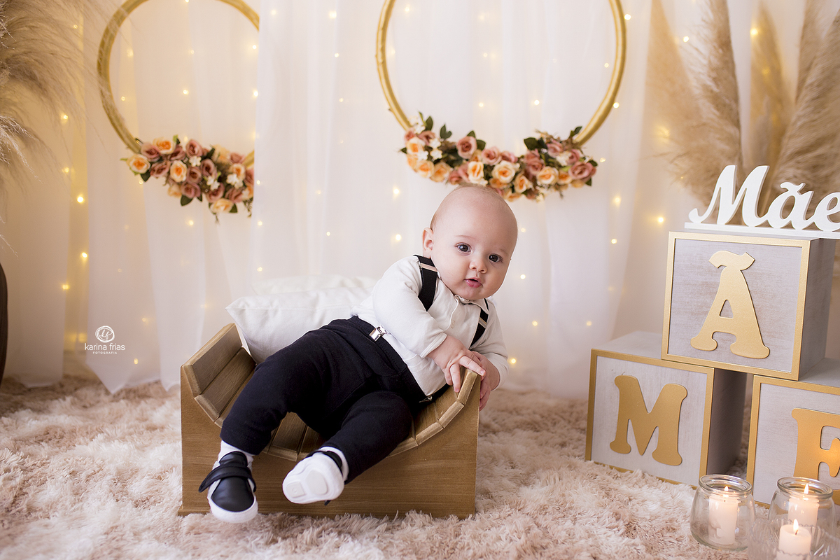 o menino posa no cenario de dia das maes para suas fotos mensais