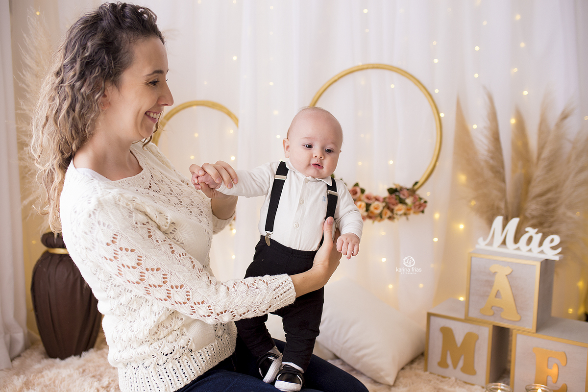 o bebe esta no colo da mae para a sessão de fotos