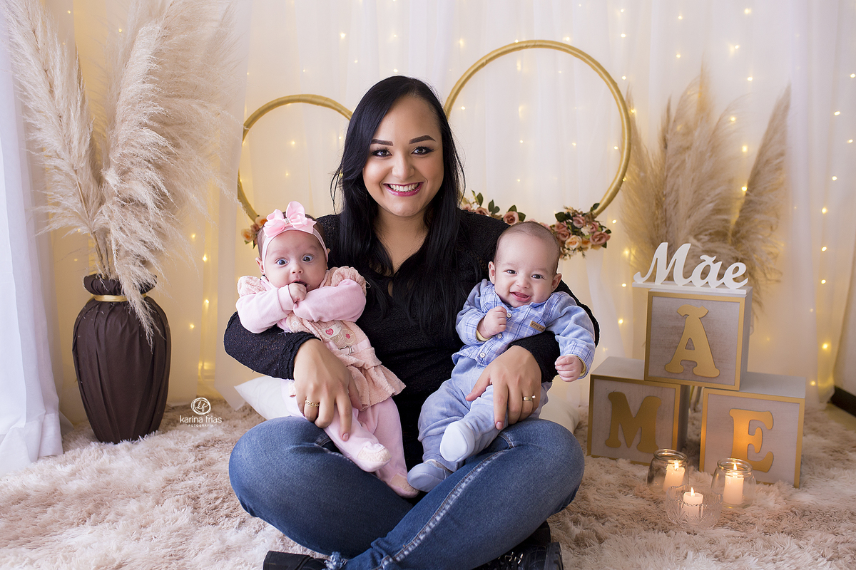 a mae segura os gemeos no ensaio fotografico