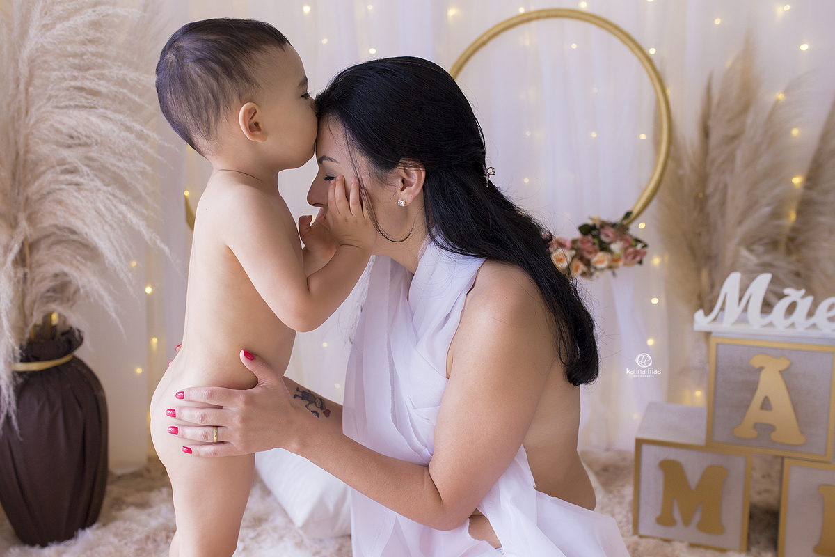 o menino beija a testa da mae durante ensaio