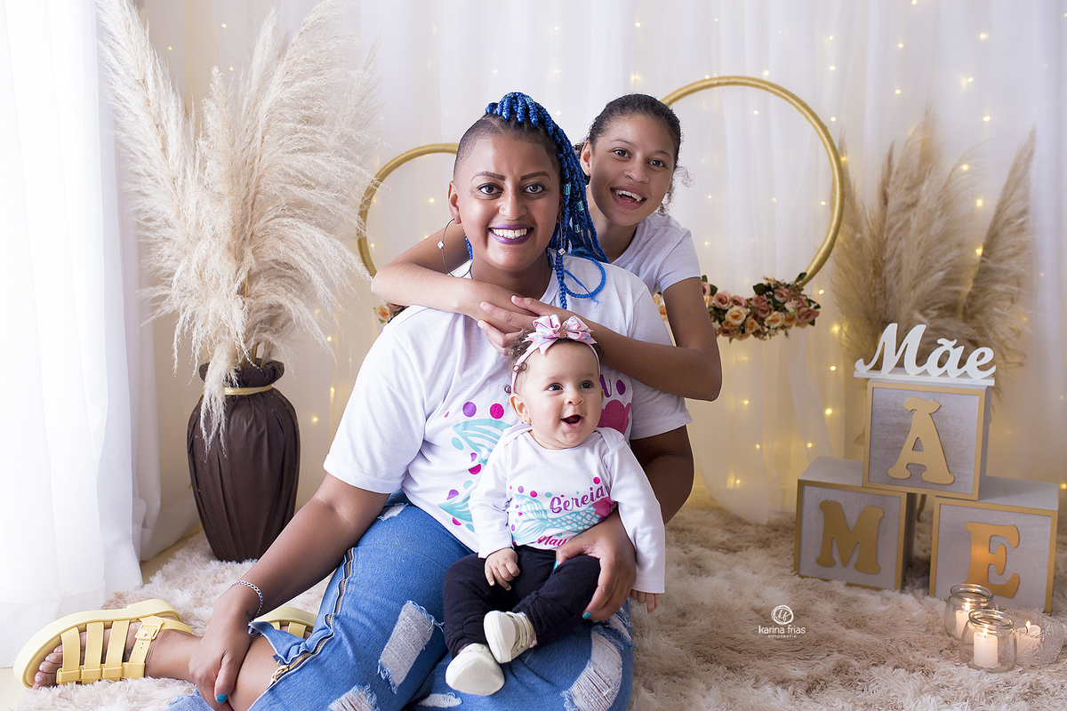 a mae posa com as filhas no ensaio de dia das maes