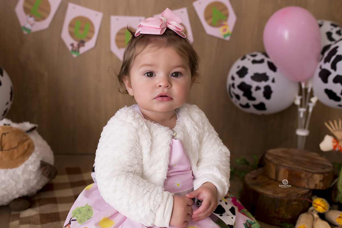 no ensaio smash the cake a menina olha para a fotografa de caxias do sul, karina frias