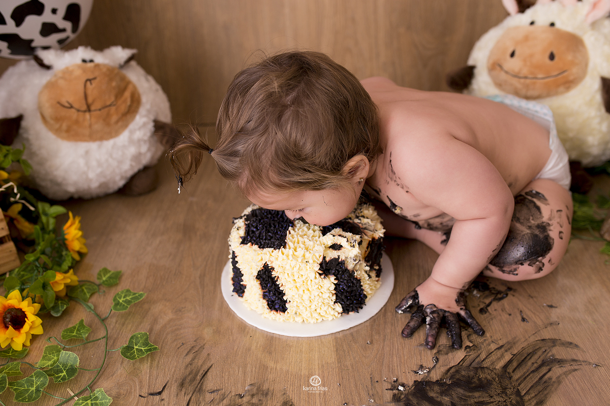 no ensaio com bolo, a menina poe o rosto direto na torta