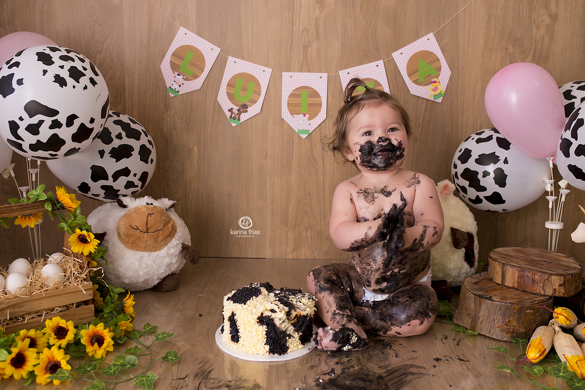 a menina se divertiu no ensaio infantil de um aninho