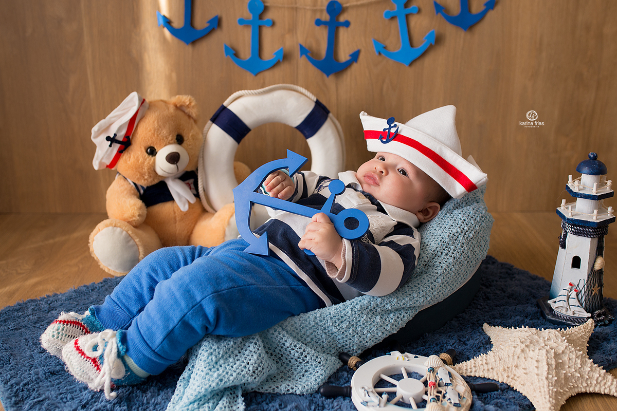 a criança fica deitada no barco enquanto a fotografa de bebes de caxias do sul registra o momento