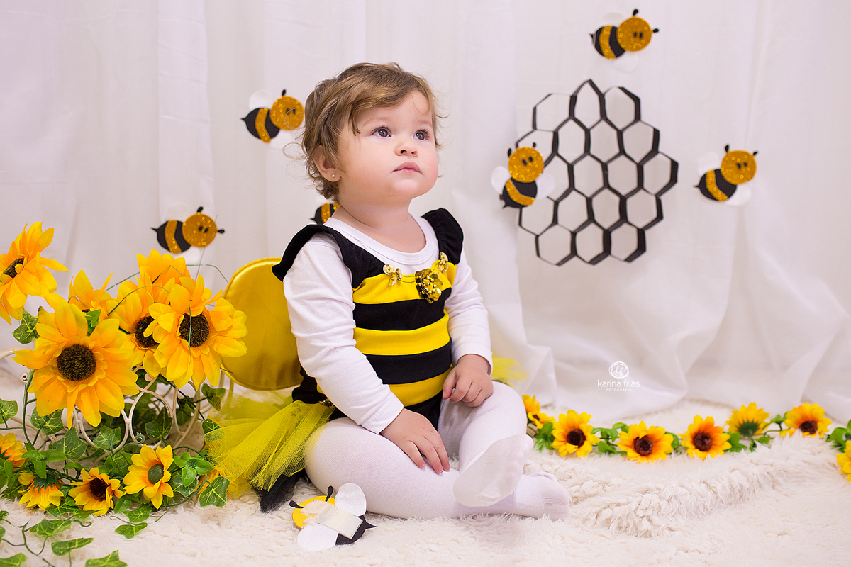 A MENINA SENTA NO CENARIO DE ABELHINHA PARA AS FOTOS MENSAIS
