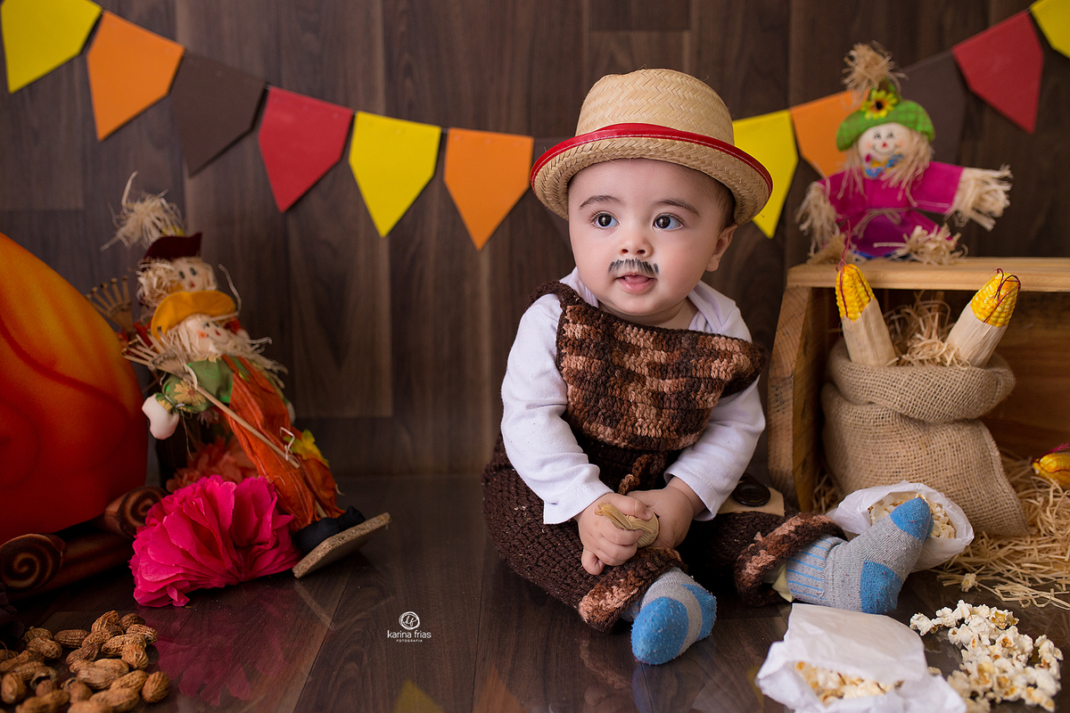 O MENINO ESTA VESTIDO DE CAIPIRA PARA AS FOTOS MENSAIS