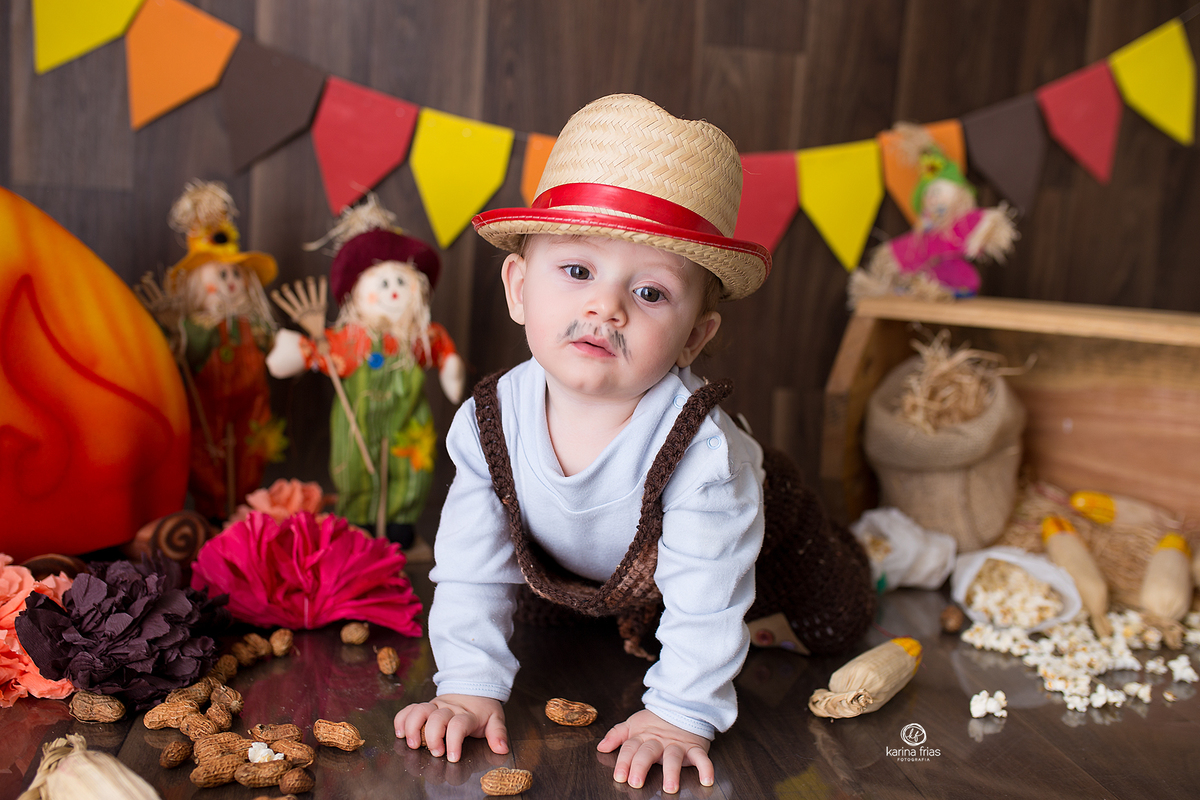 NO ACOMPANHAMENTO MENSAL O MENINO ESTA VESTIDO DE CAIPIRA