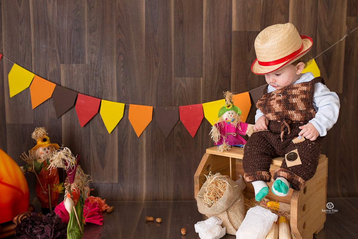 O MENINO ESTA SENTADO NO CAIXOTE PARA AS FOTOS DE ACOMPANHAMENTO MENSAL
