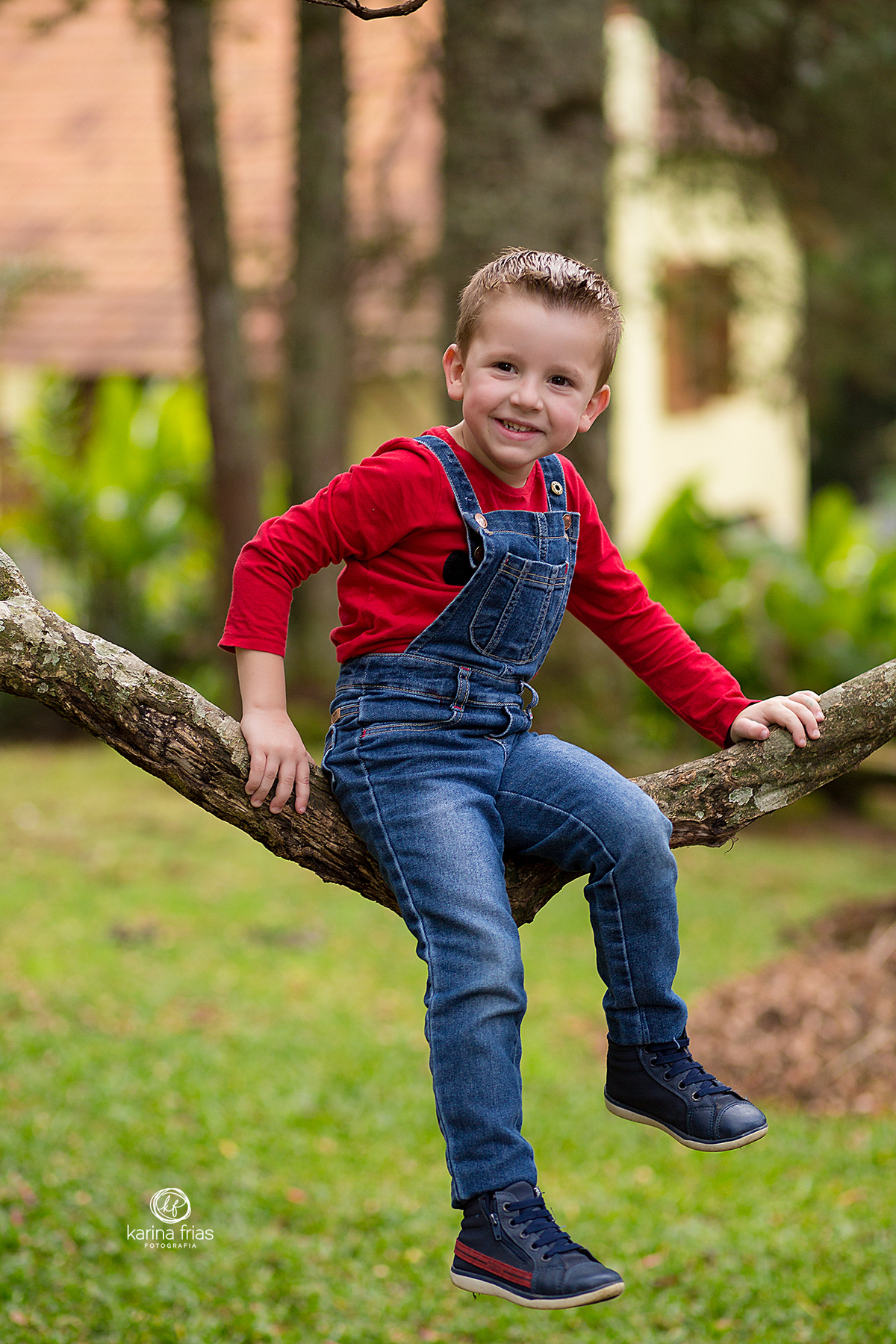 o menino fica sentado na arvore para as fotos externas
