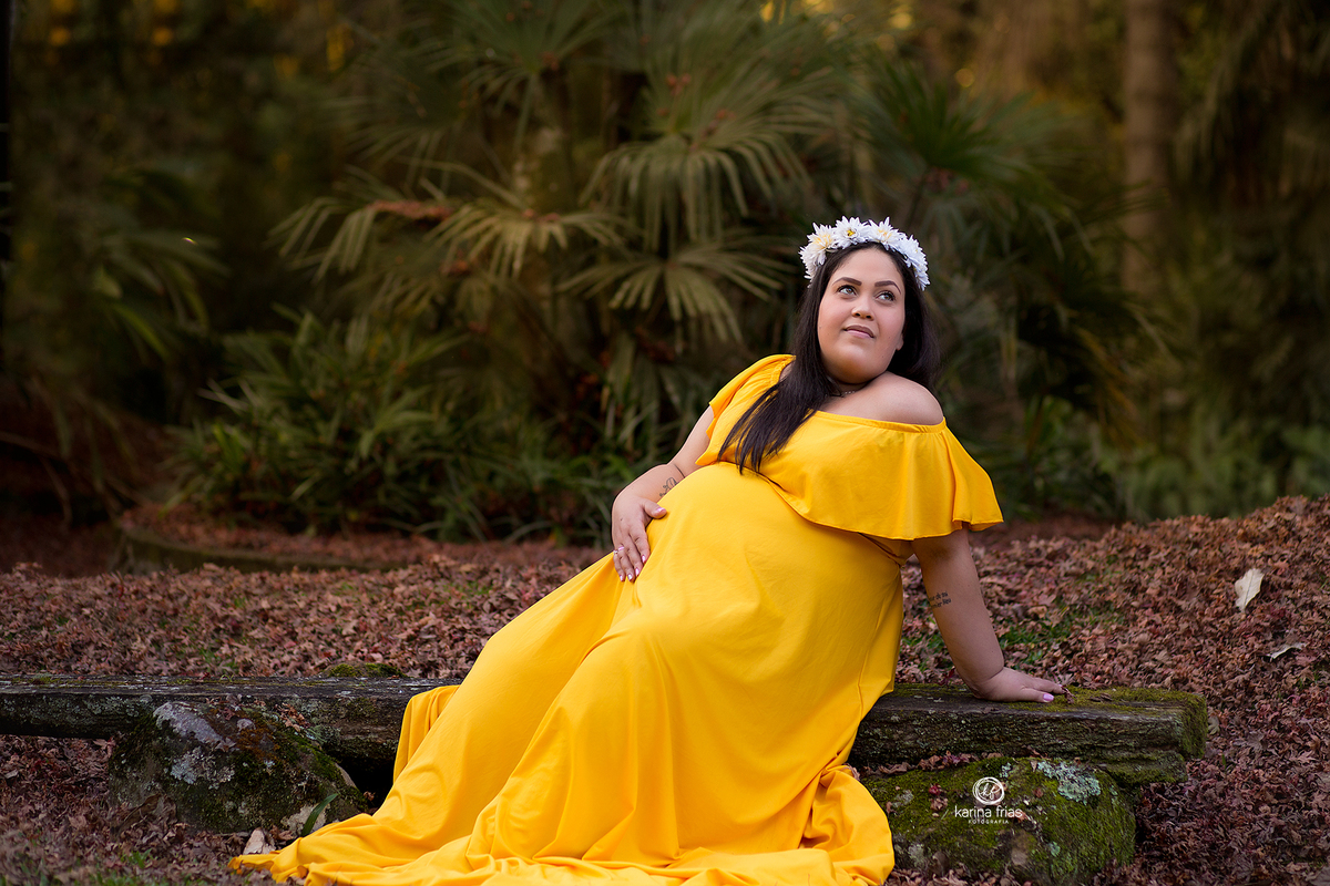 a gestante olha o horizonte durante as fotos do book externo