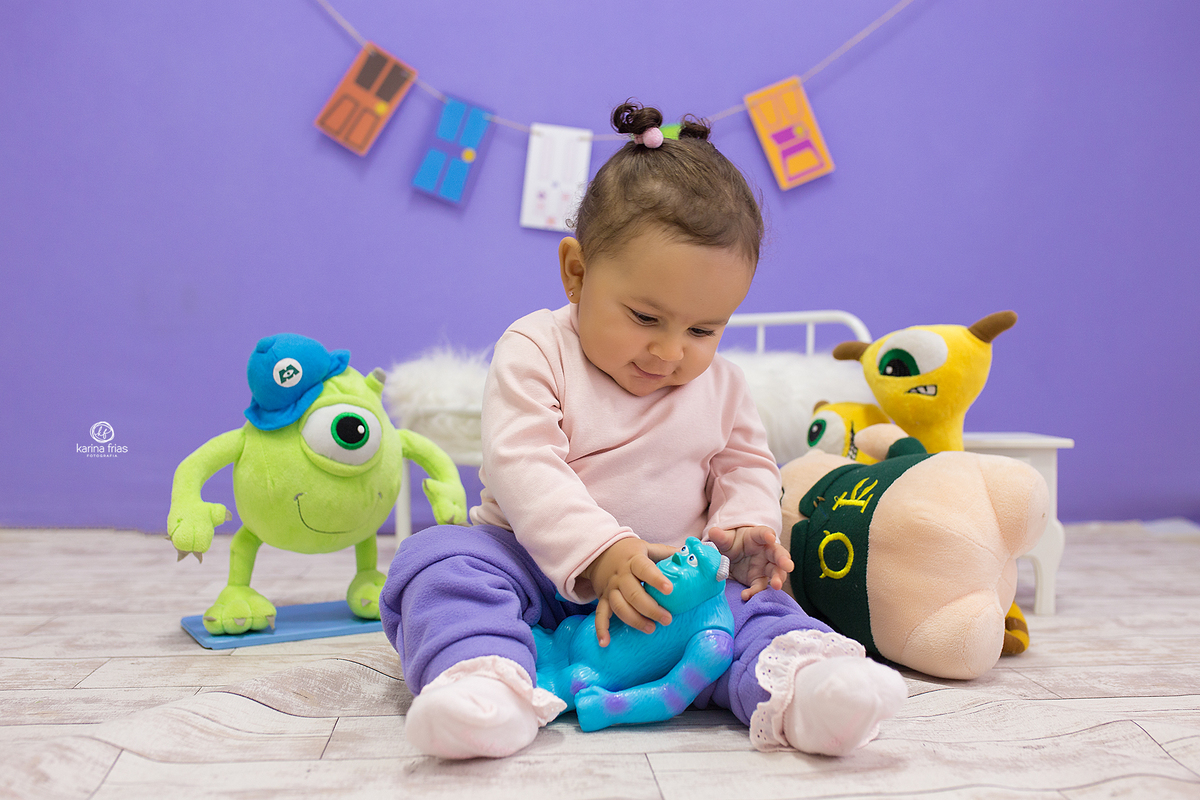 durante o ensaio a menina brinca com os bonecos
