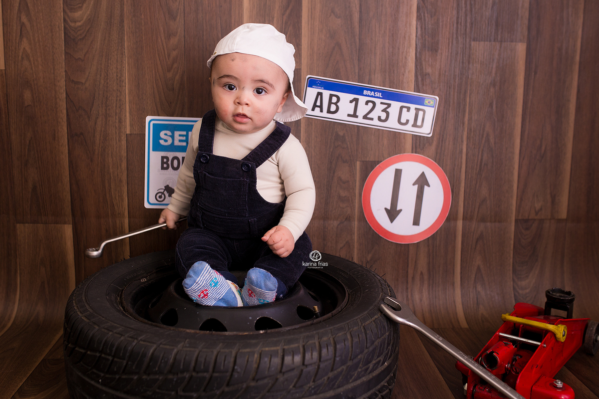 o bebe esta sentado no pneu durante ensaio infantil