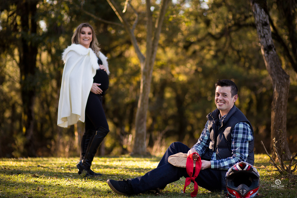 o pai segura acessorios e a gestante fica ao fundo