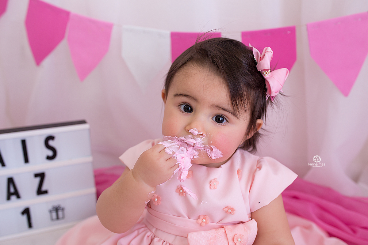 a criança come o bolo durante ensaio fotografico