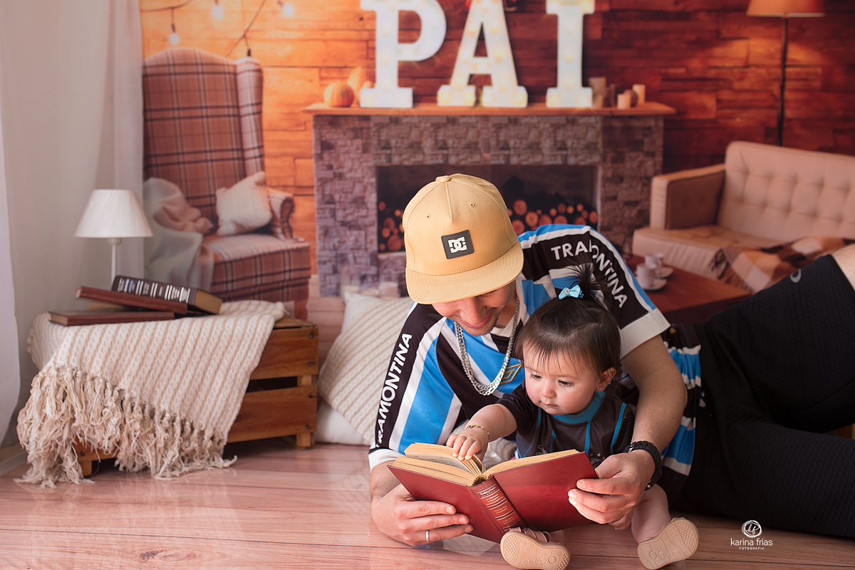 o pai le para a filha durante sessão de fotos em estudio de caxias do sul
