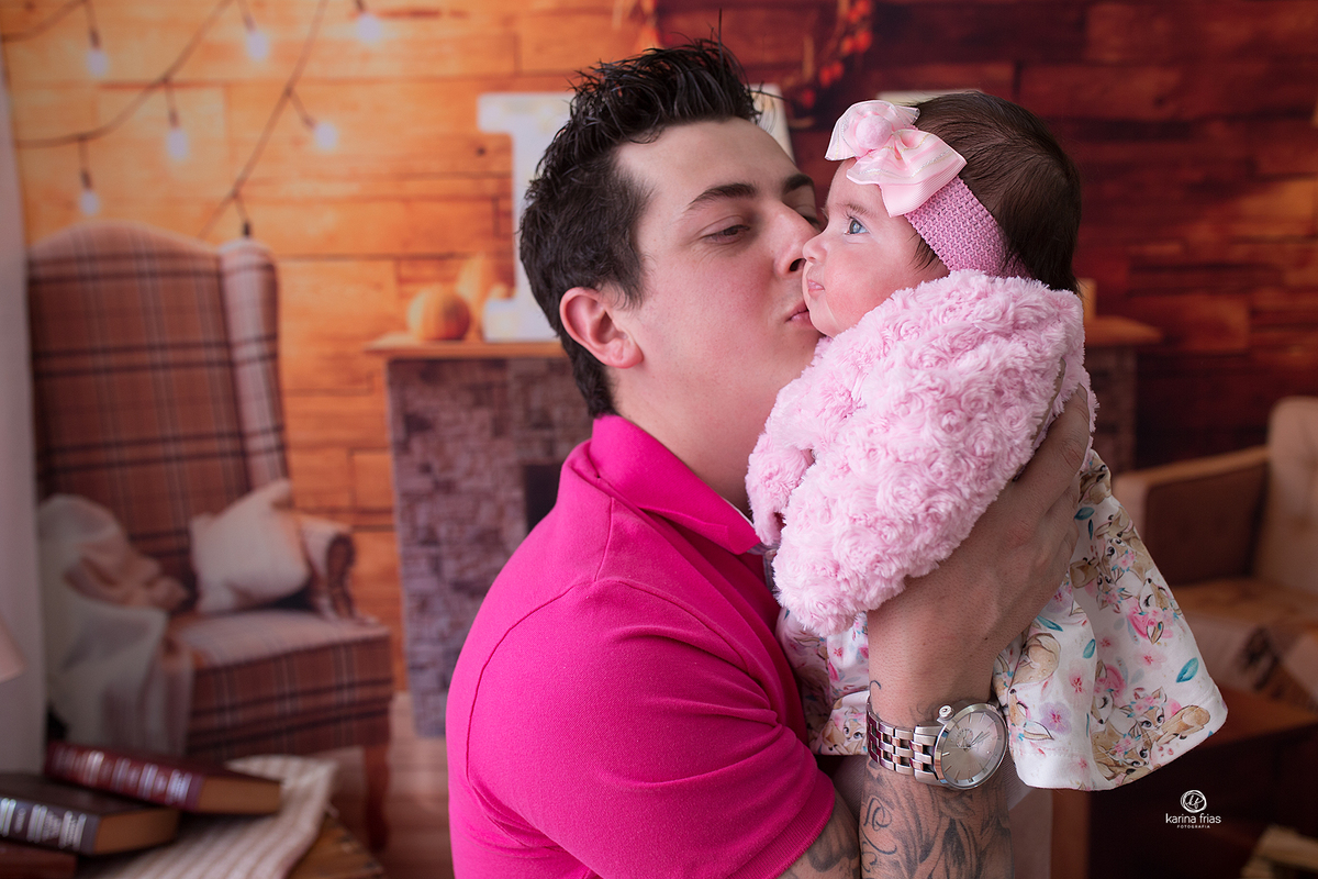 o pai beija a criança durante sessão de fotos infantis