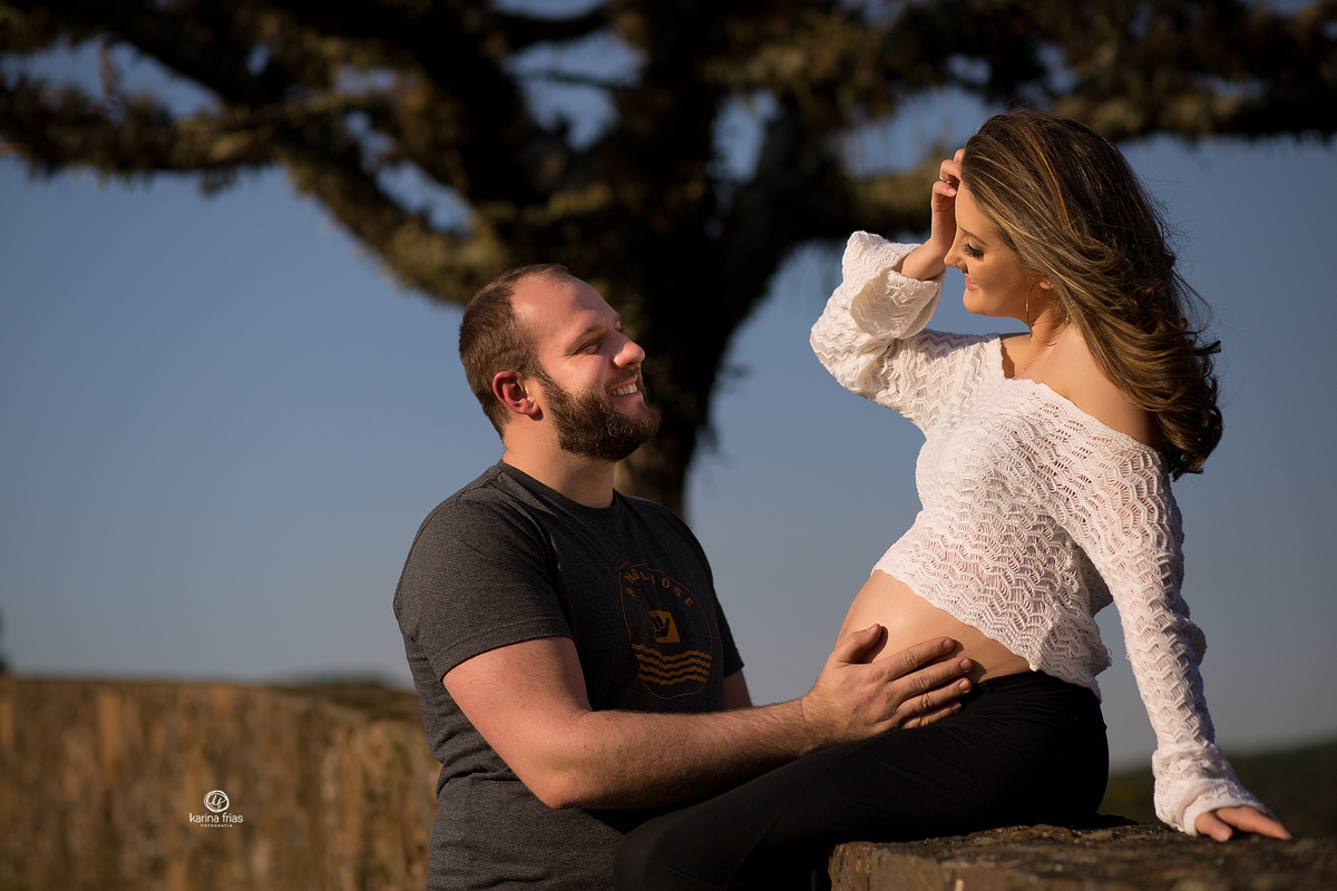 os pais se olham no ensaio externo de gestante