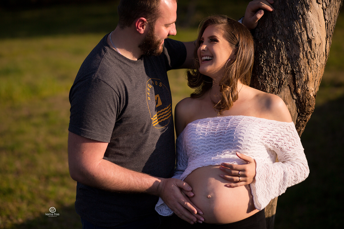 os pais sorriem enquanto a fotografa de caxias do sul registra o momento
